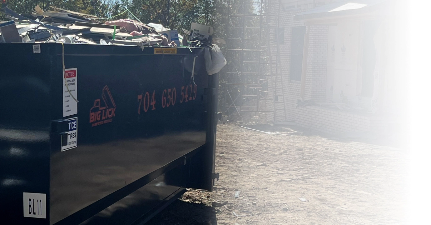 black dumpster filled with debris